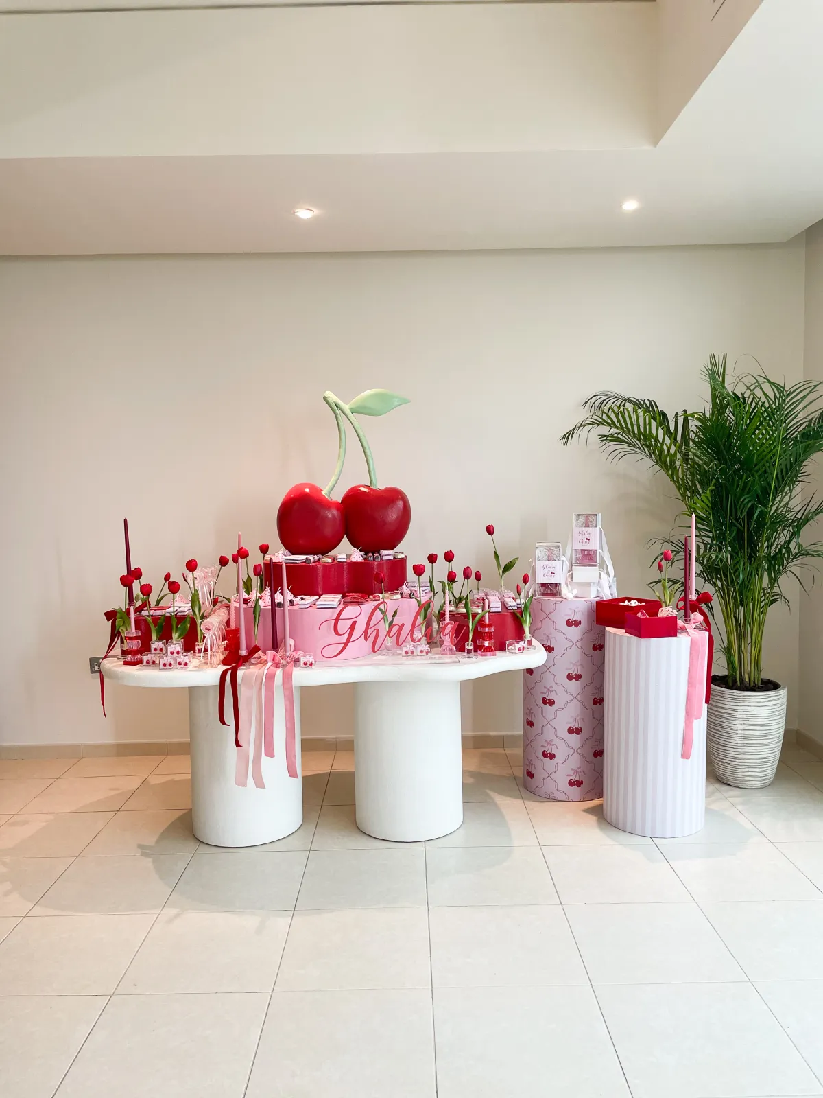 A red cherry themed newborn welcoming with a giant cherry centrepiece and chocolates