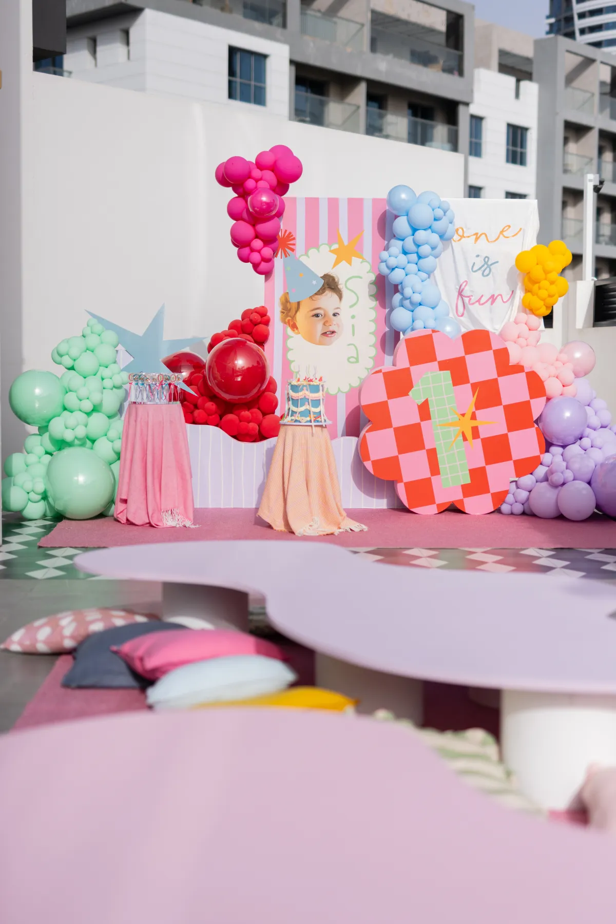 A colourful one of fun first birthday setup with bright balloons