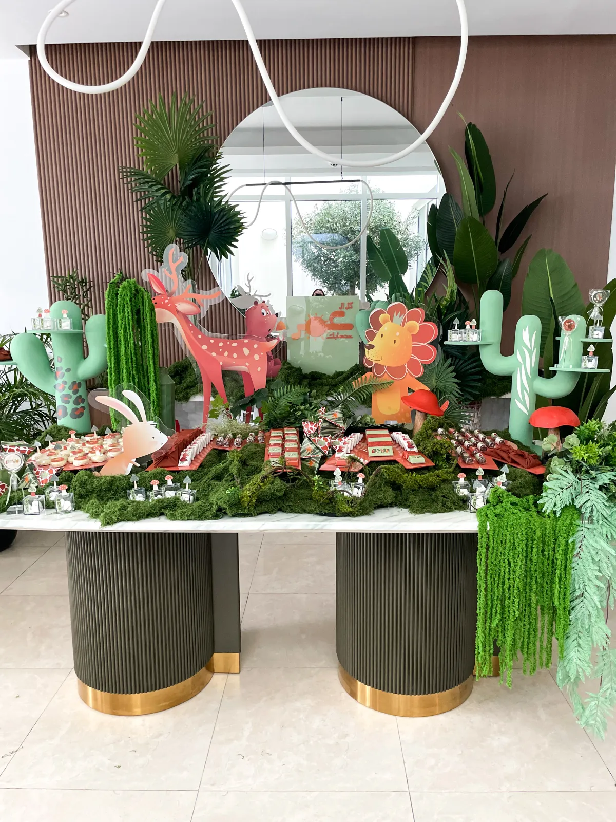 A green jungle themed newborn welcoming with giraffe and cactus details
